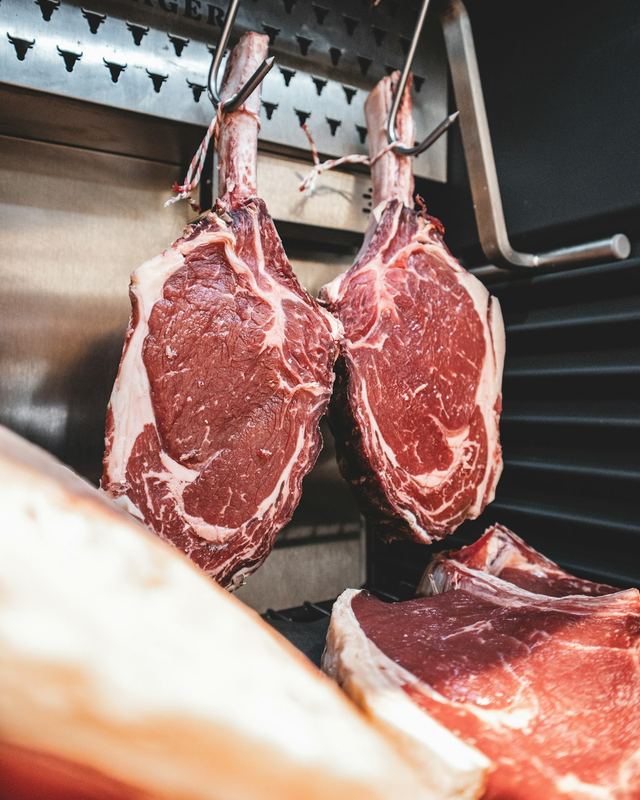 Peças de carne bovina penduradas na câmara de um açougue